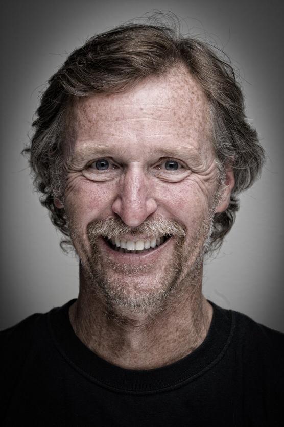 tmb happy guide A man with long hair and a beard smiling.