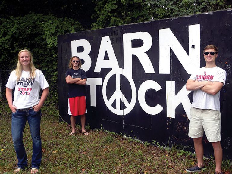dmj lkn citizen cover Three people standing in front of a barn rock sign.
