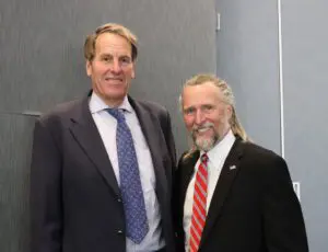 Two men in suits and ties posing for a picture.