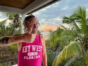 A man with dreadlocks in a pink shirt