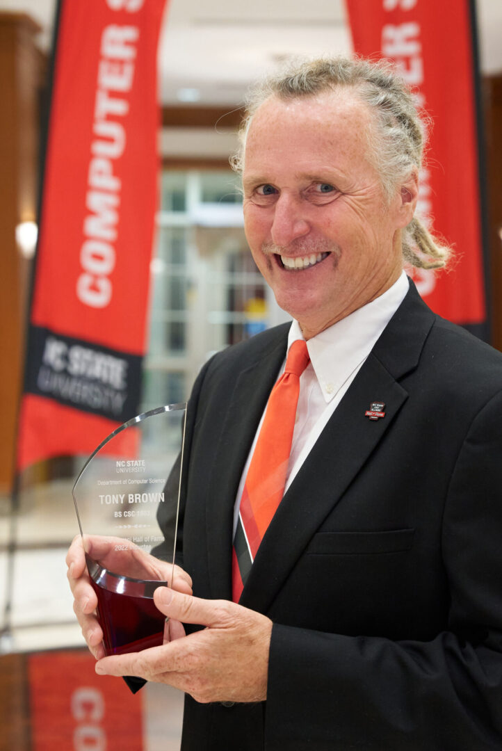 A man in suit and tie holding a glass of wine.