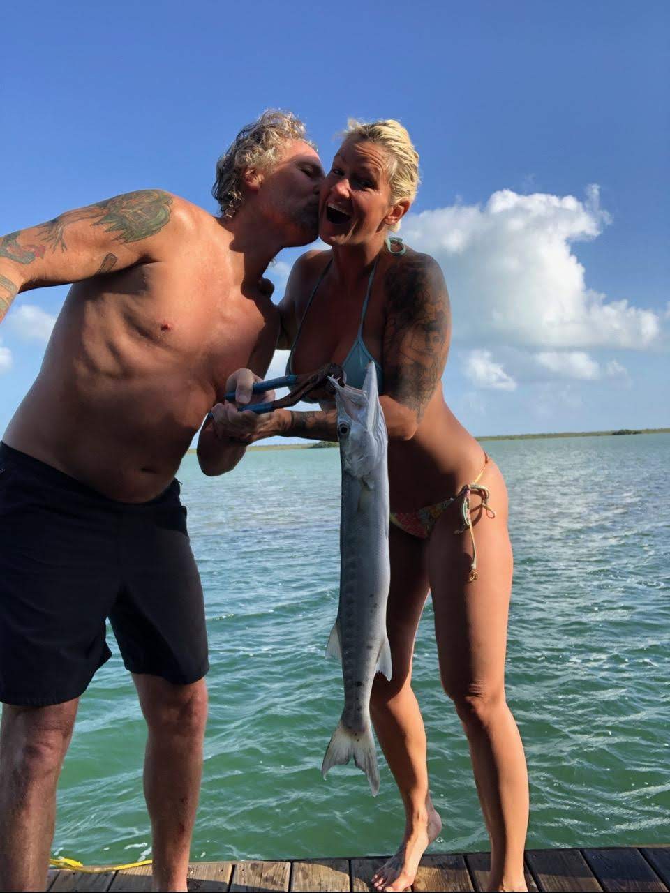 picture of couple in bathing suits with fish